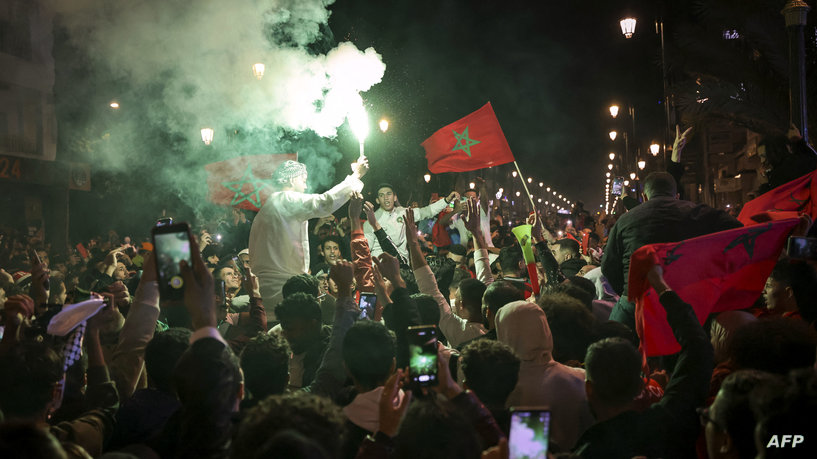 Moroccans celebrate their team's victory after the Qatar 2022 World Cup round of 16 football match between Morocco and Spain, in Rabat, on December 6, 2022. (Photo by FADEL SENNA / AFP)